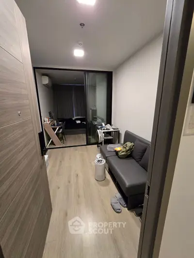 Modern apartment interior with sleek design and cozy living area, featuring a stylish sofa and wooden flooring.