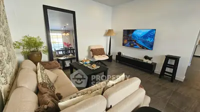 Cozy living room with modern decor, large TV, and comfortable seating, perfect for relaxation and entertainment.
