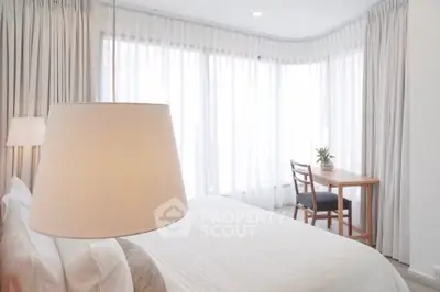 Bright and airy bedroom with large windows and elegant curtains