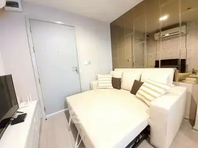 Modern living room with sleek white sofa and mirrored wall design