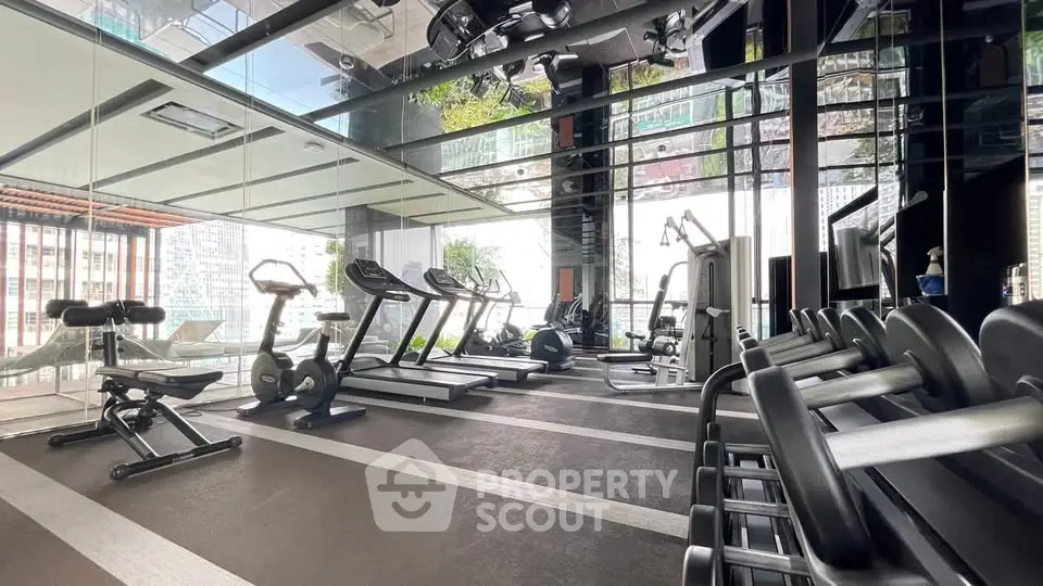 Modern gym with state-of-the-art equipment and city view in luxury residential building.