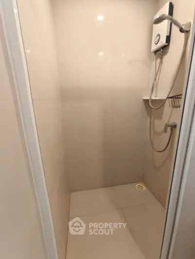 Modern shower area with sleek design and water heater in a minimalist bathroom.