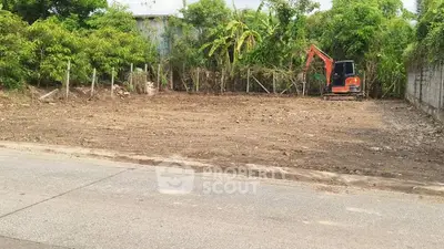 Vacant land plot with excavator, ideal for development in lush green surroundings.