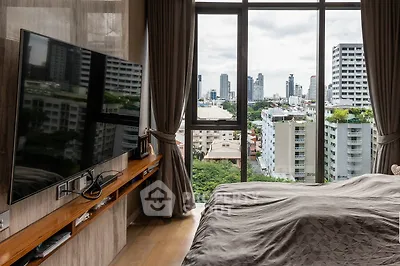Luxurious bedroom with stunning city view and modern amenities in high-rise apartment.