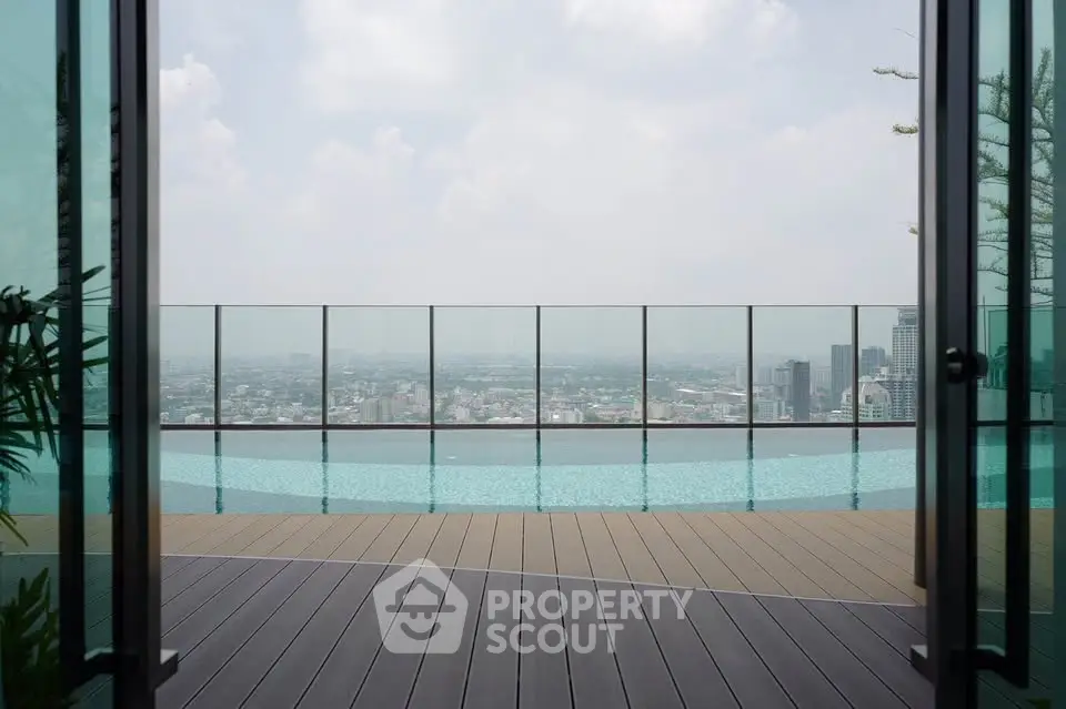 Stunning rooftop pool with panoramic city views and modern glass railing.