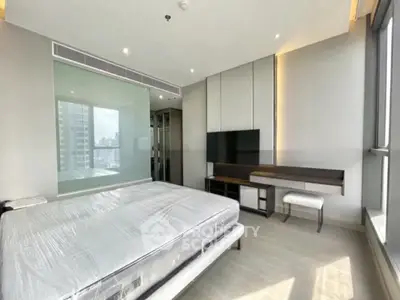 Modern bedroom with large windows and sleek furniture in a high-rise apartment.