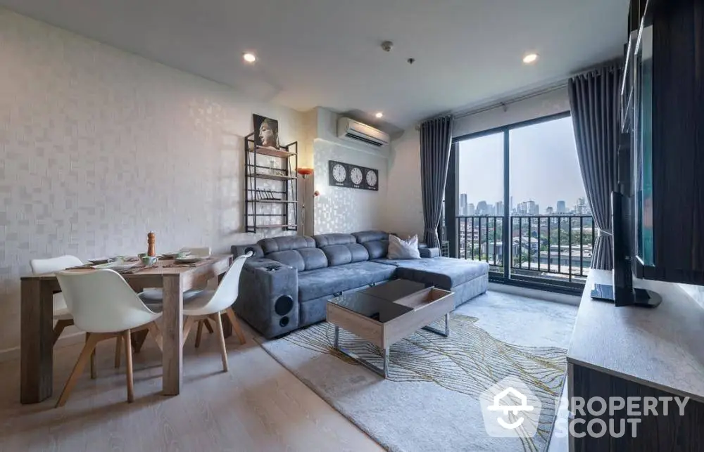 Elegant open-plan living space with modern furnishings, ample natural light, and a balcony offering city views, perfect for urban living.