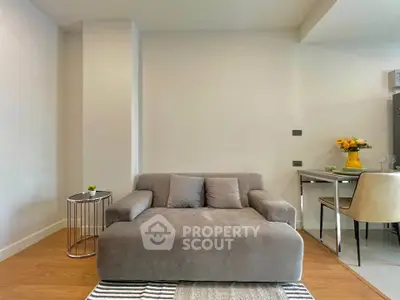 Modern living room with stylish gray sofa and dining area