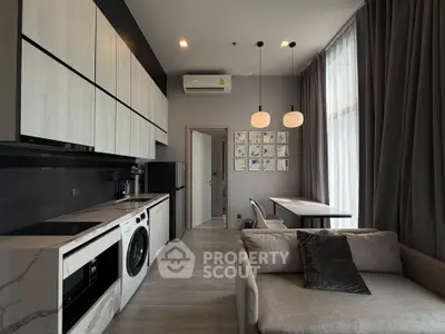 Modern living room with integrated kitchen and stylish decor in a contemporary apartment.