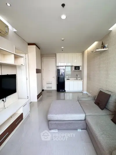 Modern living room with sleek furniture and open kitchen layout in a stylish apartment.