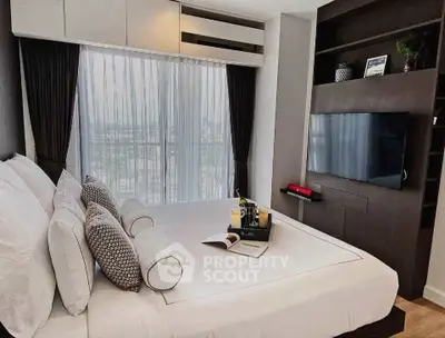 Luxurious bedroom with city view, modern decor, and wall-mounted TV in a high-rise apartment.