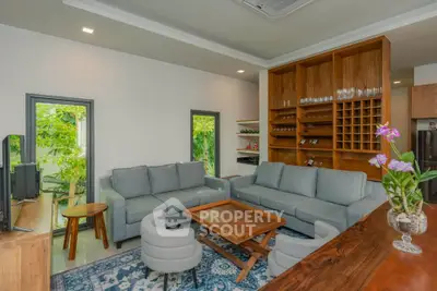 Spacious living room with modern furniture and elegant wooden accents.