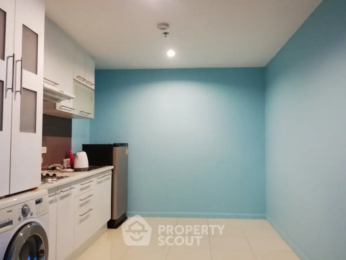 Modern kitchen with sleek appliances and vibrant blue accent wall