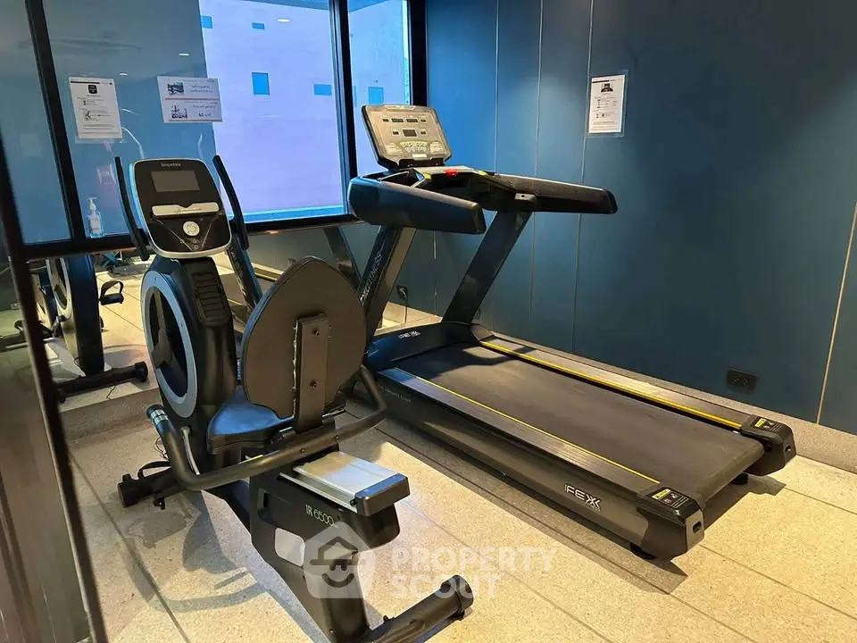 Modern gym with treadmill and exercise bike in a sleek fitness center.