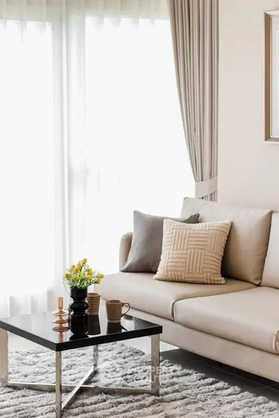 Elegant living room with plush sofa and modern coffee table in natural light.