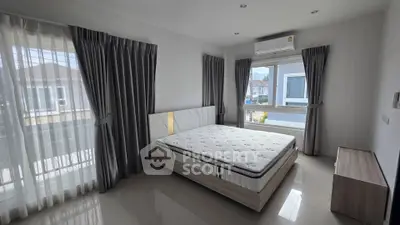 Spacious bedroom with large windows and modern decor in a bright, airy home.
