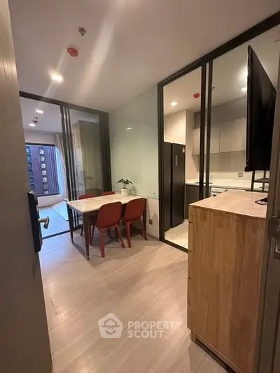 Modern kitchen with dining area and sleek glass partitions in urban apartment