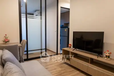 Modern living room with sleek furniture and open layout, featuring a TV and stylish decor.