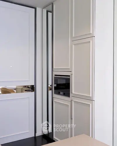 Modern kitchen with sleek cabinetry and built-in microwave oven