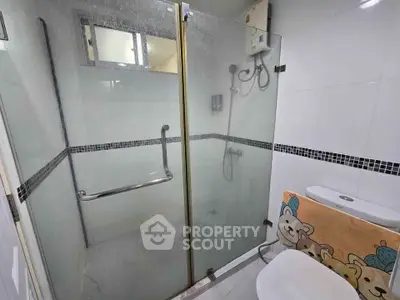 Modern bathroom with glass shower enclosure and playful decor