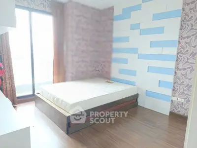 Modern bedroom with stylish accent wall and large window for natural light.