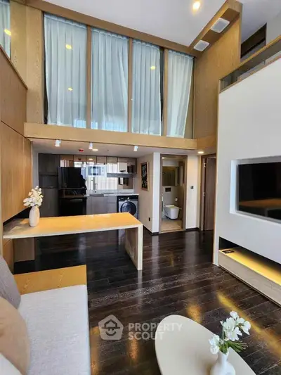 Luxurious modern living room with high ceilings and open kitchen layout, featuring elegant wood finishes and stylish decor.