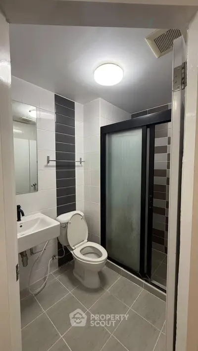 Modern bathroom with sleek shower and contemporary fixtures in a stylish apartment.