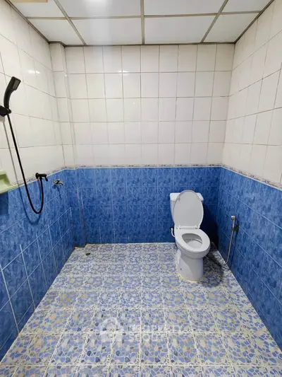 Spacious bathroom with blue and white tile design and modern fixtures.