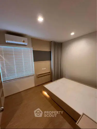 Modern bedroom with minimalist design, featuring built-in furniture and soft lighting.