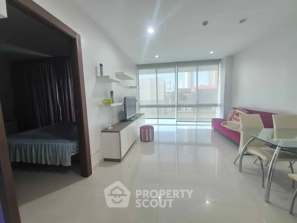 Modern living room with open layout and natural light, featuring a cozy seating area and dining space.