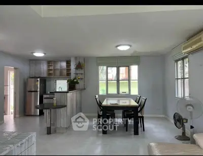 Spacious open-plan living and dining area with modern kitchen and natural light.