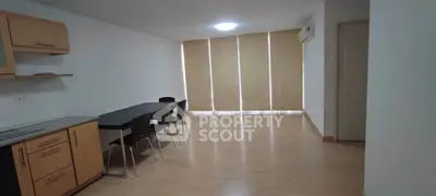 Spacious modern living room with sleek wooden flooring and minimalist design.