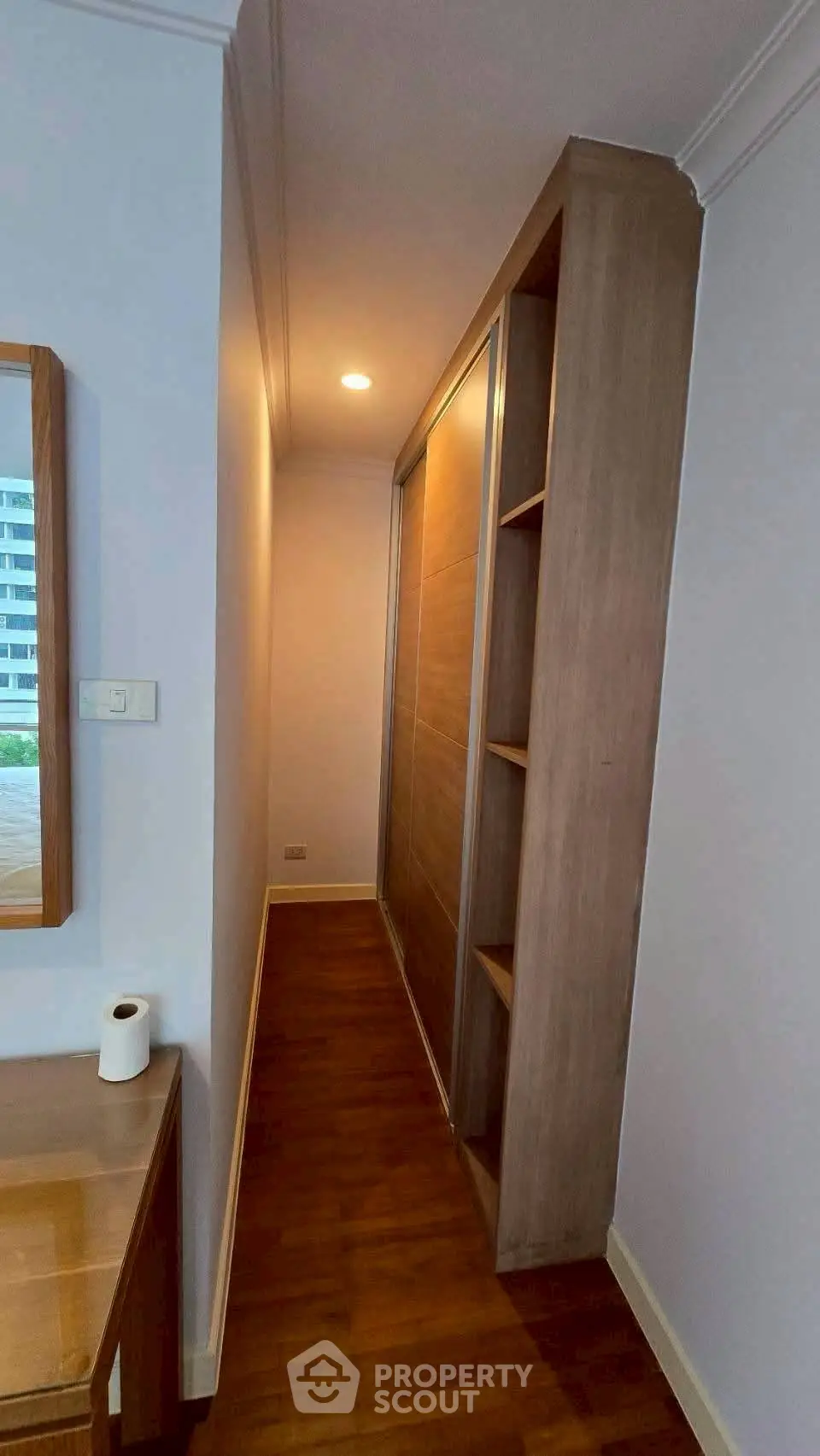 Stylish hallway with wooden flooring and built-in storage in modern apartment.