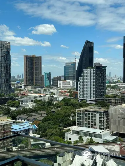 Stunning cityscape view from high-rise balcony with modern architecture and lush greenery.