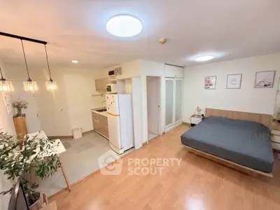 Spacious studio apartment with modern kitchen and cozy bedroom area, perfect for urban living.