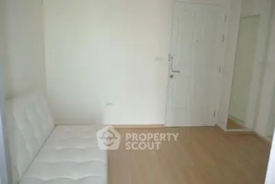 Minimalist room with white sofa and wooden floor, ideal for modern living.