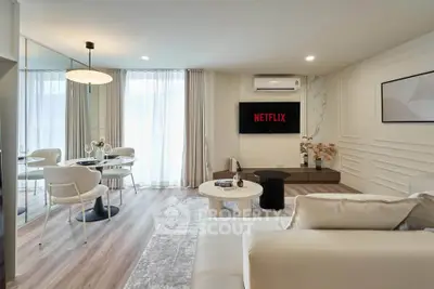 Modern living room with elegant decor, cozy seating, and dining area, perfect for relaxation and entertainment.