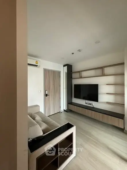 Modern living room with sleek TV unit and cozy sofa, perfect for relaxation and entertainment.