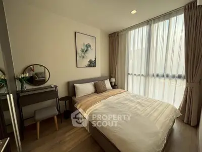 Elegant bedroom with large window and stylish decor, perfect for modern living.