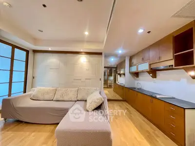 Spacious living room with modern kitchen and cozy sofa in open layout apartment.