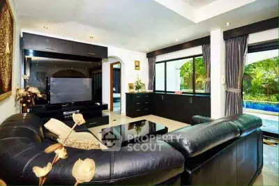 Luxurious living room with leather sofa and pool view, perfect for relaxation and entertainment.