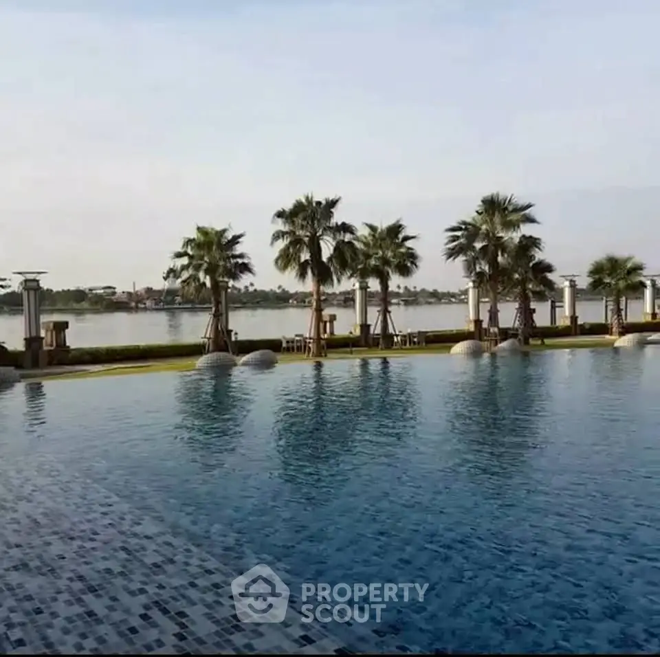 Luxurious waterfront pool with palm trees and serene lake view
