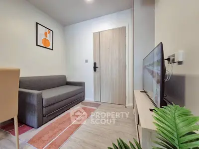 Modern living room with sleek sofa and wall-mounted TV in cozy apartment.