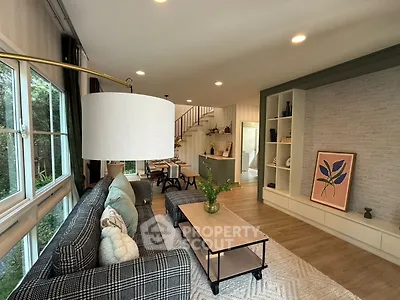 Stylish living room with modern decor and open layout, featuring large windows and elegant furnishings.