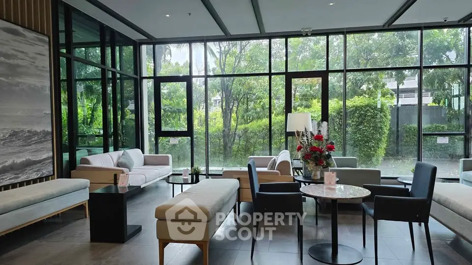 Spacious modern living room with large windows and garden view, featuring elegant furniture and decor.