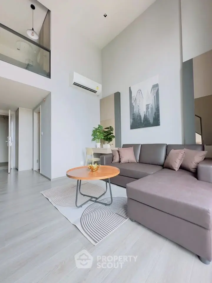 Modern living room with high ceiling and stylish decor in a contemporary apartment.