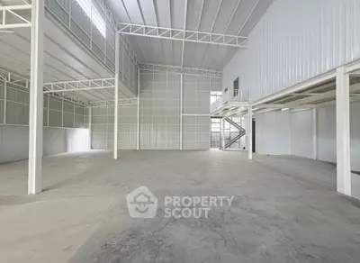 Spacious industrial warehouse with high ceilings and mezzanine level.