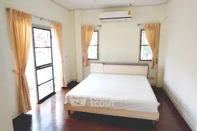 Spacious bedroom with natural light and modern air conditioning unit