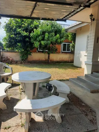 Charming garden patio with stone seating set, perfect for outdoor relaxation and entertaining.
