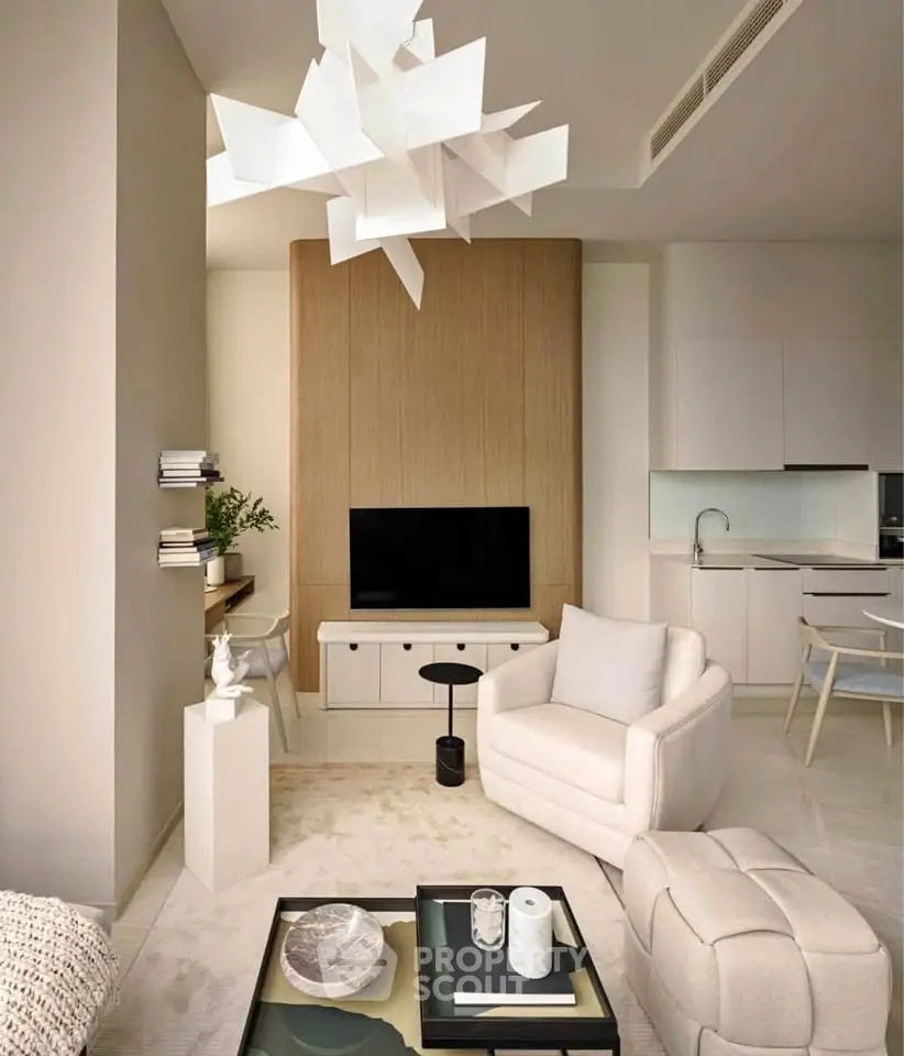 Modern living room with stylish furniture and open kitchen layout, featuring a unique ceiling light fixture.